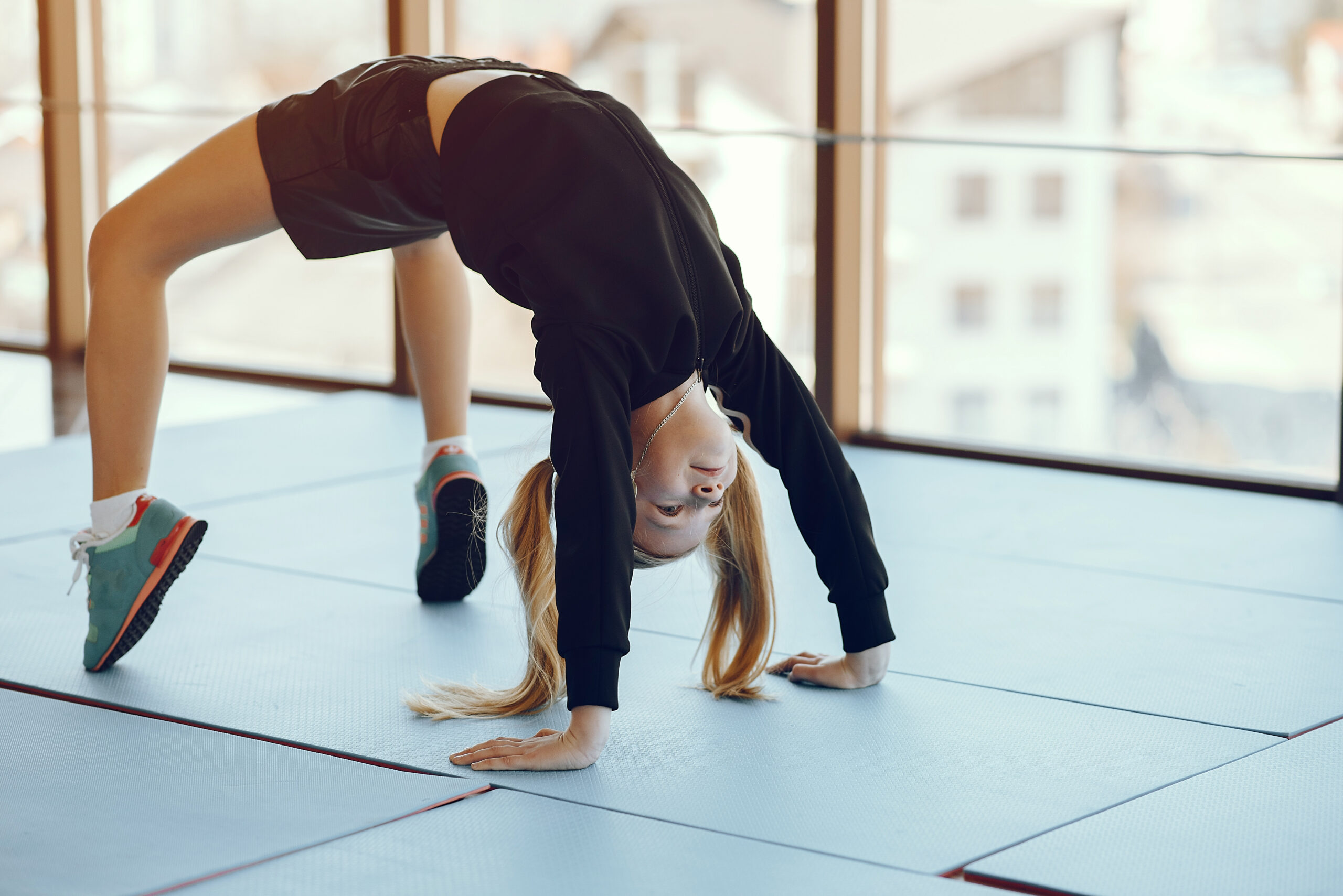 A beautiful little girl is engaged in a gym Beautiful girl in the gym. Child performs exercises.